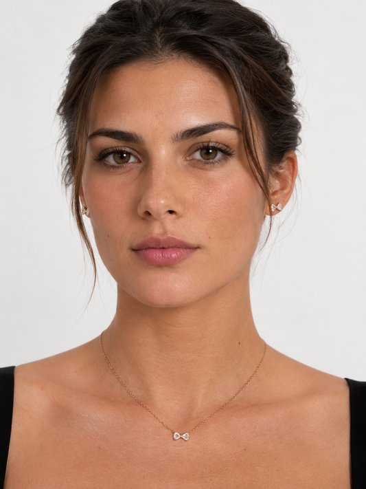 Model wearing crystal bow necklace and earrings